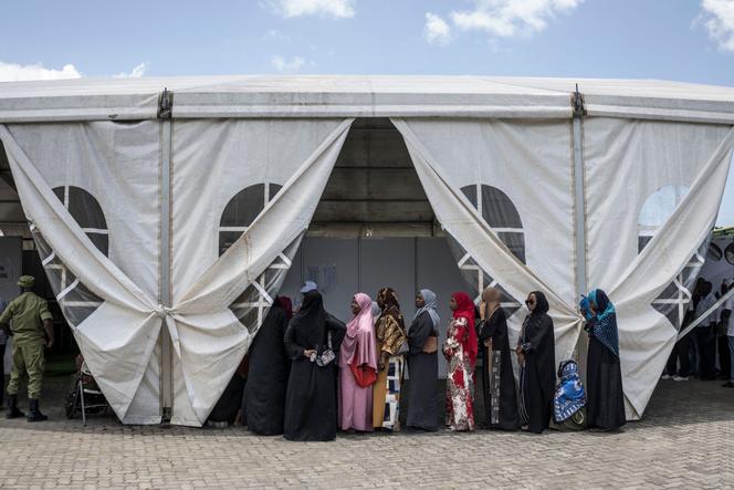 Des électeurs font la queue pour voter devant un bureau de vote installé près d’un parc d’attractions à Stone Town, le 29 octobre 2025.