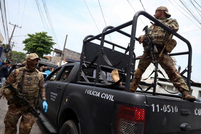 Un membre de l’unité tactique de la police, à l’arrière d’un véhicule transportant un corps, lors d’une opération de police contre le trafic de drogue dans la favela de la Penha, à Rio de Janeiro, au Brésil, le 28 octobre 2025.