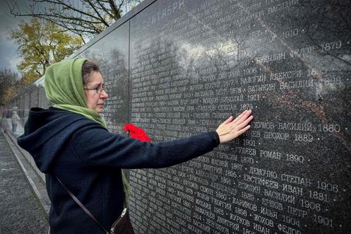 Une femme au mémorial dédié aux victimes des répressions politiques à Boutovo, près de Moscou, le 30 octobre 2025, à l’occasion d’une Journée du souvenir.