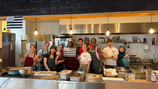  Voluntários na cozinha acompanhados pelo chef Kany (no centro, durante a preparação da noite bretã, na Cop1ne, em 2025.