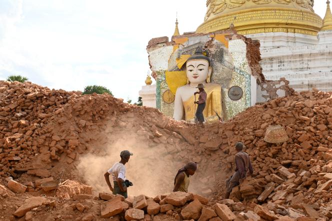 Des habitants déblaient les décombres d’une statue de Bouddha endommagée à la pagode Lawkatharaphu d’Inwa, en périphérie de Mandalay, le 12 avril 2025.