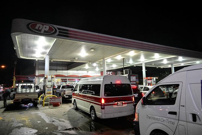 Des personnes font le plein dans une station-service à Port of Spain, le 31 octobre 2025. 