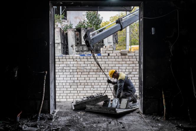 Des ingénieurs électriciens se débarassent de décombres et de gravats d’une sous-station électrique endommagée par une attaque de drones russes, à Odessa (Ukraine), le 23 octobre 2025.