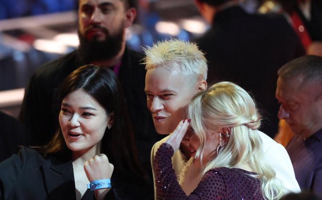 Le chanteur Iaroslav Dronov (connu sous son nom de scène Shaman) et Ekaterina Mizoulina posent pour une photo avec une spectatrice avant le début du concours de musique Intervision 2025,&nbsp;à Moscou, le 20&nbsp;septembre 2025.