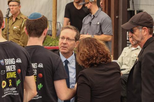 Президент Израиля Ицхак Герцог (в центре) с семьей Омера Нойтры на его похоронах на кладбище Кирьят-Шауль в Тель-Авиве 7 ноября 2025 года.