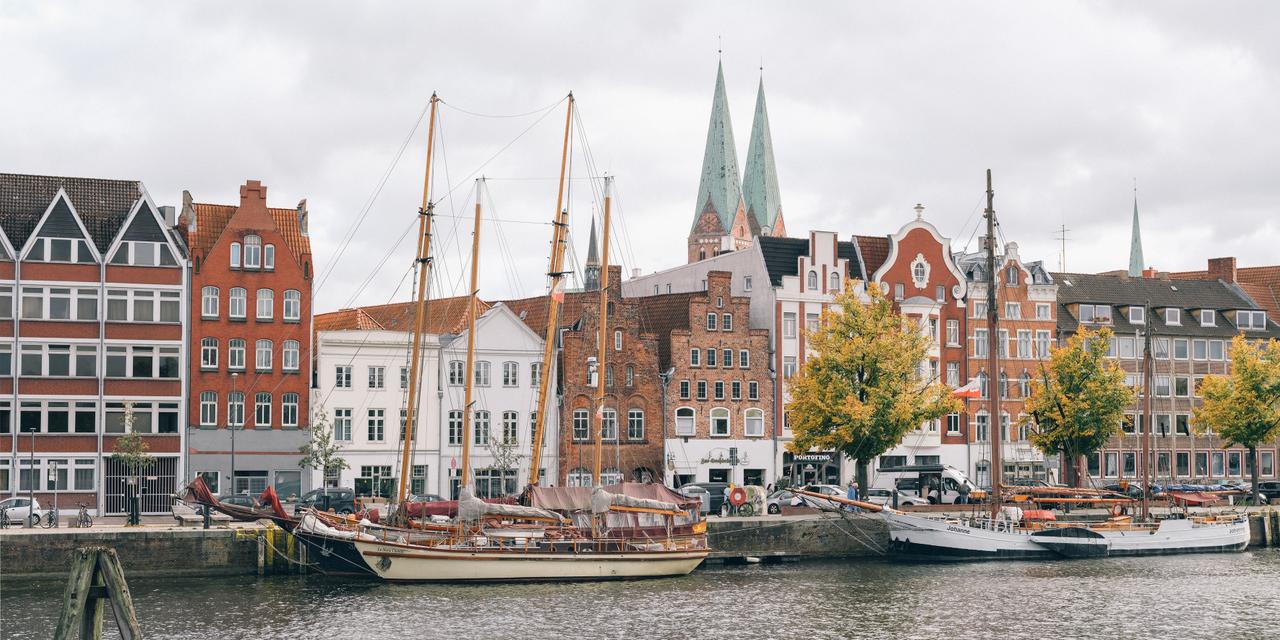 Maisons au bord de la rivière Trave avec les tours de l’église Sainte-Marie en arrière-plan.