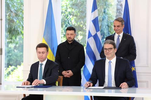 Le premier ministre grec Kyriakos Mitsotakis (à droite, à l’arrière-plan) et le président ukrainien Volodymyr Zelensky (à gauche, à l’arrière-plan) posent avec Konstantinos Xifaras, directeur général de DEPA S.A. (en bas à droite), et Sergii Koretsky, directeur général de la Compagnie nationale ukrainienne d’électricité Naftogaz, après la signature d’un accord au palais Maximos à Athènes, le 16 novembre 2025.