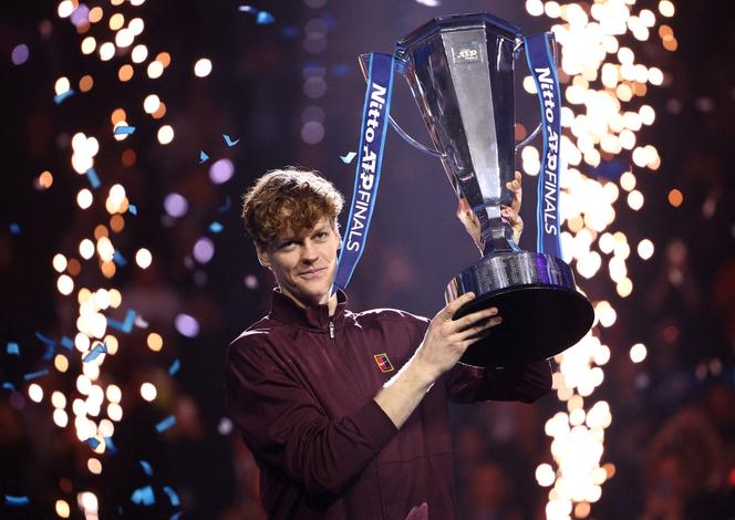 Italy's Jannik Sinner celebrates with his trophy after winning the ATP finals against Spain's Carlos Alcaraz in Turin, Italy, on November 16, 2025.