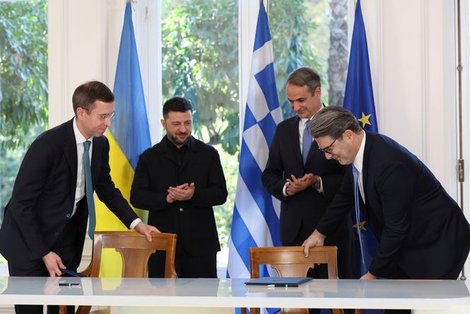 Le président ukrainien, Volodymyr Zelensky (à gauche) et le premier ministre grec, Kyriakos Mitsotakis (à droite), applaudissent Serhi Koretsky, directeur général de la Compagnie nationale ukrainienne d’électricité Naftogaz (à gauche), et Konstantinos Xifaras, directeur général de DEPA SA (à droite), après la signature d’un accord au palais Maximos d’Athènes, le 16 novembre 2025. 