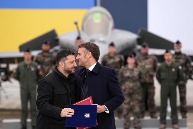 Emmanuel Macron et le président ukrainien, Volodymyr Zelensky, s’enlacent après la signature d’un accord sur la base aérienne de Villacoublay (Yvelines), près de Paris, le 17 novembre 2025. 