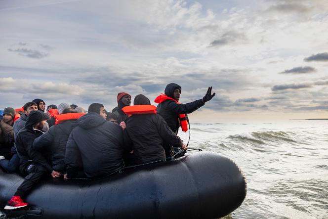 Des migrants face à des policiers français, alors qu’ils tentent de traverser la Manche à bord d’un bateau de passeurs, sur la plage de Gravelines (Nord), près de Dunkerque, le 26 avril 2024.