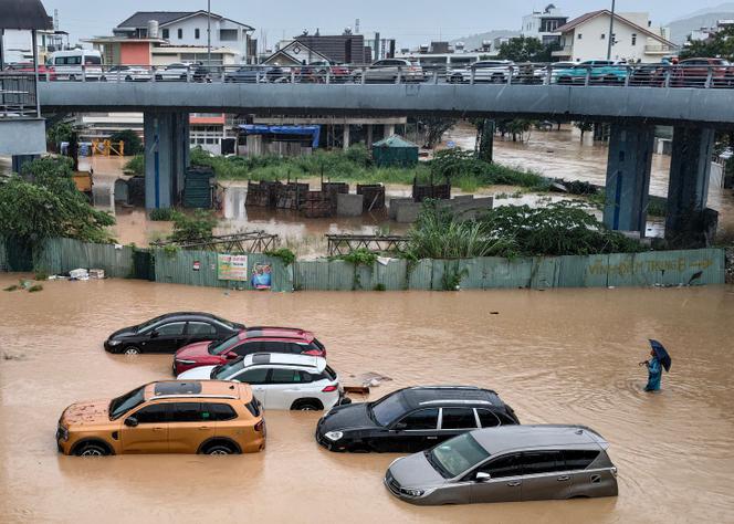 Un homme patauge dans les eaux de crue près de véhicules inondés à Nha Trang, dans la province côtière vietnamienne de Khanh Hoa, le 20 novembre 2025. 