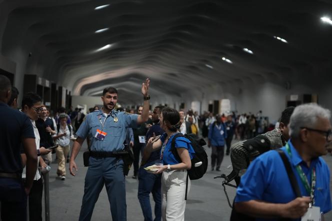 A security officer asks those present to leave the COP30 location, Thursday, November 20, 2025, in Belem, Brazil, when a fire broke out at the location.