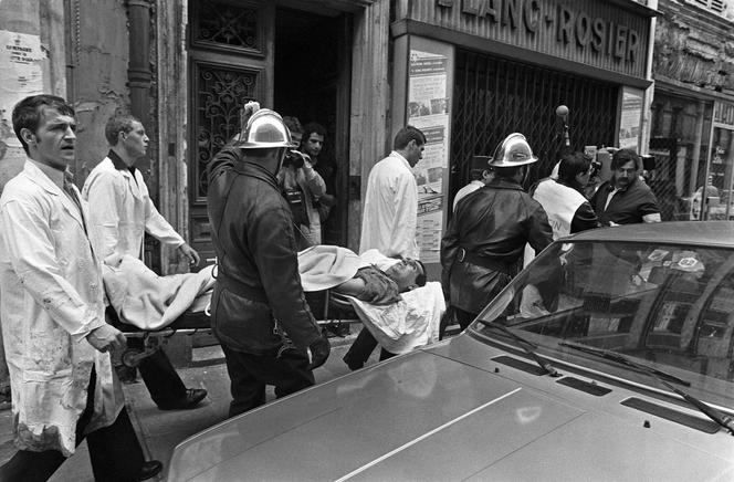 Bombeiros e paramédicos evacuam um ferido do ataque à rue des Rosiers, em Paris, em 9 de agosto de 1982.
