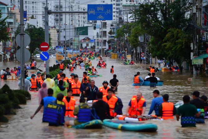 Cette photo prise le 20 novembre 2025 montre des personnes pataugeant dans les eaux de crue à Nha Trang, dans la province côtière de Khanh Hoa, au Vietnam.