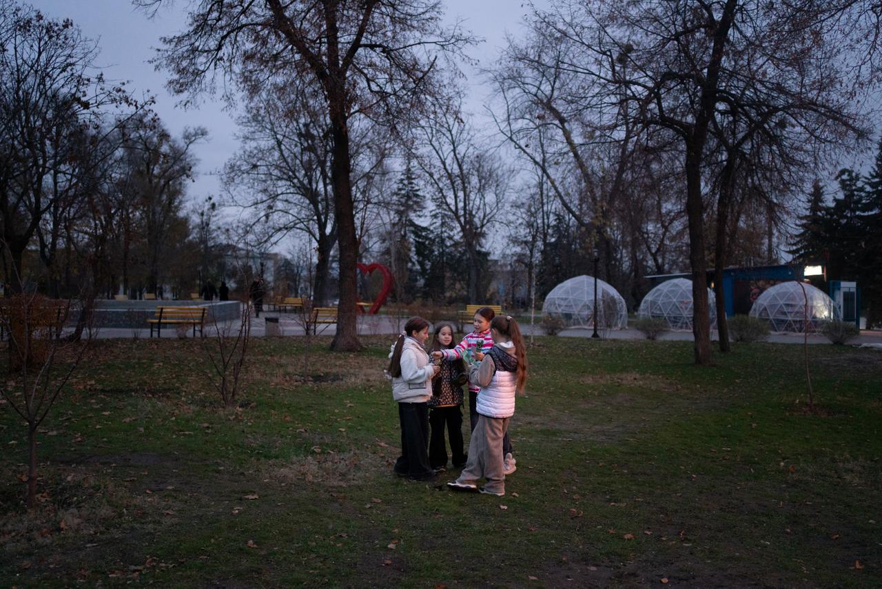 Des enfants jouent au crépuscule, dans le centre-ville d’Izioum, en Ukraine, le 10 novembre 2025.