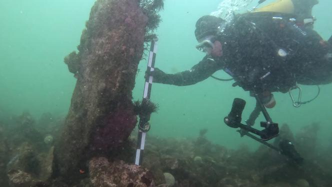 Le chercheur Philippe Bodénès près d’un monolithe planté dans le mur de Toul ar Fot, au large de l’île de Sein (Finstère).