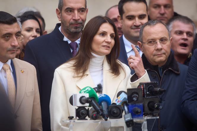 Anca Alexandrescu (au centre) annonce sa candidature au poste de maire de Bucarest, le 14 novembre 2025. A sa gauche, George Simion, le chef du parti d’extrême droite AUR, qui soutient sa candidature.