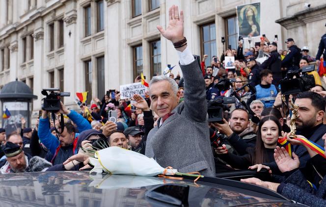 Calin Georgescu, ancien candidat souverainiste qui avait remporté le premier tour de l’élection présidentielle roumaine annulée de 2024, salue ses partisans en quittant la cour d’appel de Bucarest, le 17 novembre 2025.