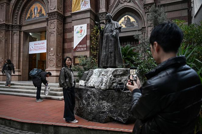 Devant la statue du défunt pape Jean XXIII, à l’extérieur de l’église Saint-Antoine-de-Padoue, tandis qu’une banderole de bienvenue à Léon XIV trône, avant sa visite en Turquie. A Istanbul, le 24 novembre 2025.