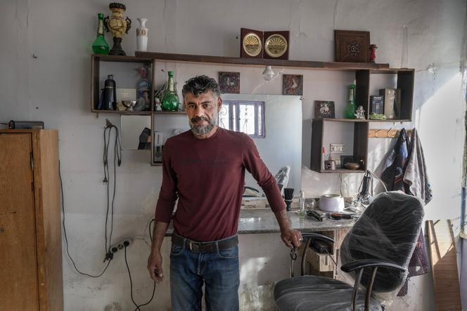 Mohammed Al-Dari, 46 ans, dans le salon de coiffeur barbier qu’il essaie d’ouvrir, à Harran Al-Awamid, dans la Ghouta orientale, en Syrie, le 31 octobre 2025.