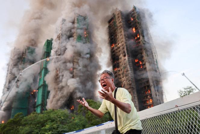 A man reacts as his wife is trapped inside the Wang Fuk Court housing complex during a large fire in Tai Po, Hong Kong, China, November 26, 2025.