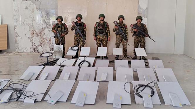 Cette photo prise le 20 octobre 2025 et publiée le 22 octobre 2025 par l’équipe d’information militaire de la Birmanie montre des membres de l’armée birmane debout à côté d’appareils Starlink saisis lors d’une descente dans le centre d’escroquerie en ligne KK Park à Myawaddy, dans l’Etat de Kayin.