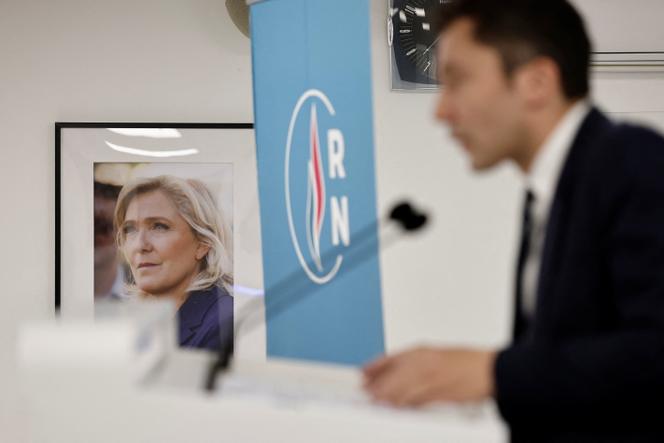 Julien Sanchez, directeur de campagne des municipales pour le RN, devant un portrait de Marine Le Pen, lors d’une conférence de presse tenue au siège du parti à Paris, le 1ᵉʳ décembre 2025.