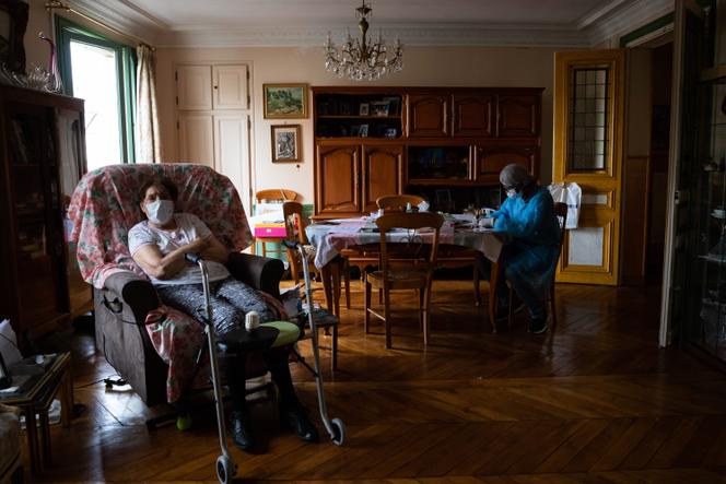 Une auxiliaire de vie chez une personne âgée, à Paris, en avril 2020.