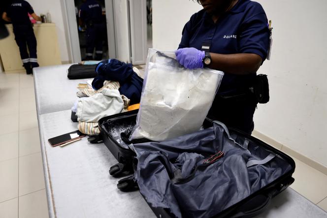Des douaniers français découvrent de la cocaïne cachée dans la valise d’un passager à destination de Paris au départ de Cayenne, à l’aéroport international de Cayenne, en Guyane française, le 24 mars 2024. 
