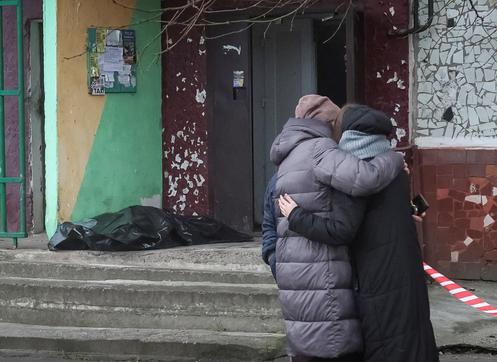 Des habitants devant le corps d’une personne retrouvée morte dans un immeuble touché par une frappe de drone russe, survenue tard dans la soirée de lundi, dans la ville de Kramatorsk, oblast de Donetsk, le 2 décembre 2025.