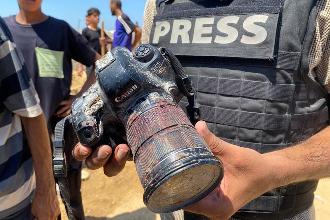 Un journaliste tenant l’appareil photo couvert de sang appartenant à la photojournaliste palestinienne Mariam Dagga, qui a été tuée lors d’une frappe israélienne sur l’hôpital Nasser, à Khan Younès, dans le sud de la bande de Gaza, le 25 août 2025.