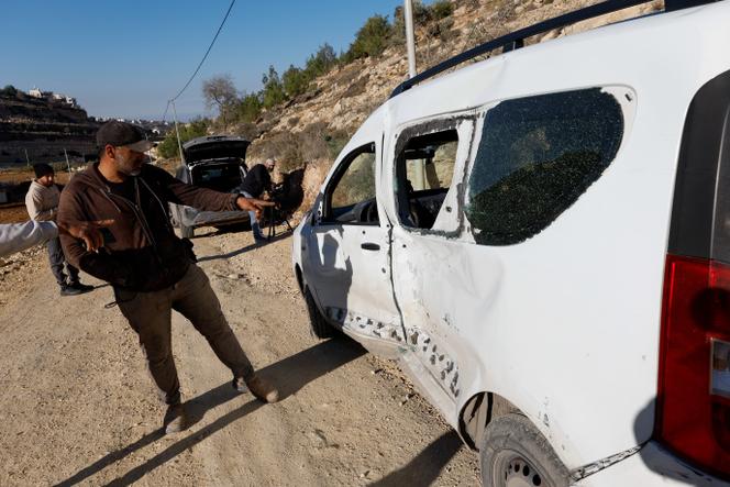 Des personnes montrent du doigt un véhicule endommagé, après que les forces israéliennes ont abattu son conducteur âgé de 17 ans, qui, selon l’armée israélienne, avait percuté des soldats avec sa voiture, à Hébron, en Cisjordanie, mardi 2 décembre 2025. 