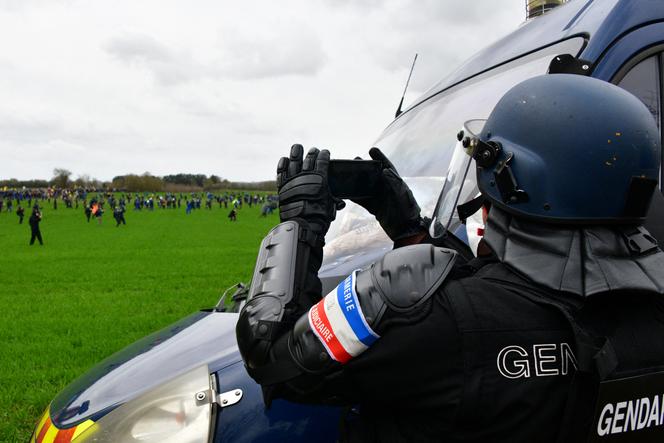 Un gendarme photographie les participants à une manifestation contre les mégabassines, à Sainte-Soline (Deux-Sèvres), le 25 mars 2023.