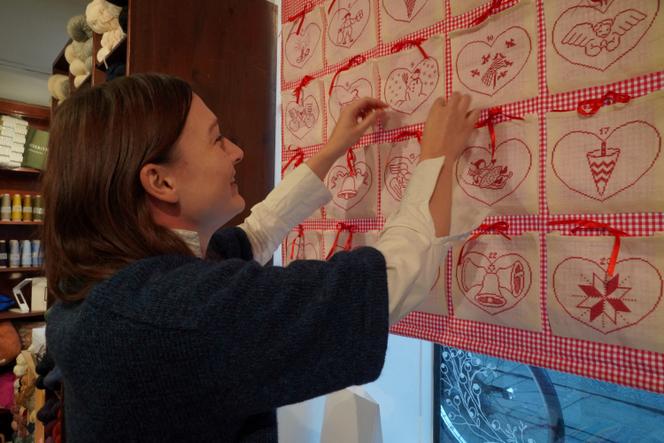 Thilde Melby, co-owner of the Sommerfuglen craft store in Copenhagen, shows an advent calendar with an embroidery pattern designed by Denmark's Queen Margrethe II, in Copenhagen, Denmark, January 11, 2024. REUTERS/Tom Little