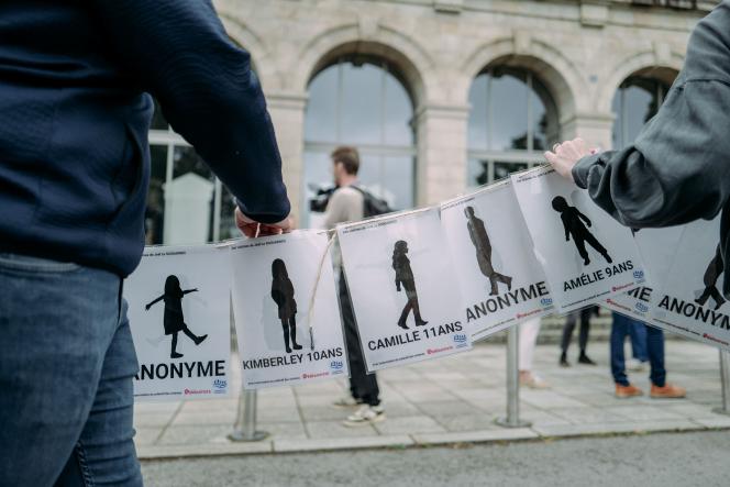 Des manifestants tiennent des pancartes, dont certaines portent les noms des victimes de Joël Le Scouarnec, à Vannes, dans le Morbihan, le 28 mai 2025.