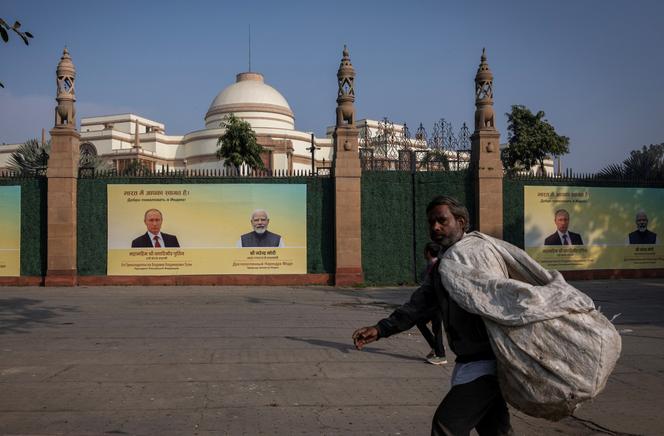 Un chiffonnier passe devant des affiches présentant les portraits du président russe Vladimir Poutine et du premier ministre indien Narendra Modi, la veille de la visite du chef du Kremlin, à New Delhi, en Inde, le 4 décembre 2025.