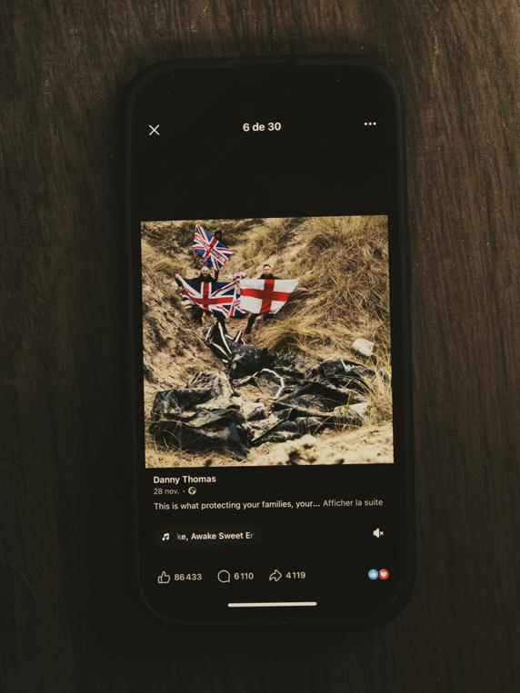 Une photo postée sur les réseaux sociaux par « Danny » Thomas, représentant des embarcations détruites sur une plage, et des membres du mouvement Raise the Colours brandissant des drapeaux britanniques. A Gravelines (Nord), le 5 décembre 2025. 