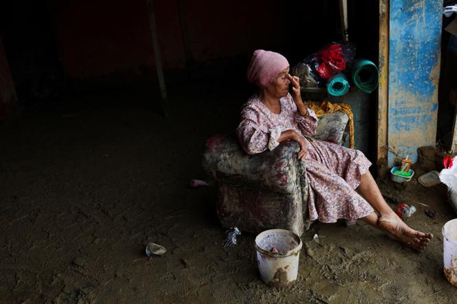 La rescapée Rosmaniah Nasution, 70 ans, fait une pause après avoir récupéré des biens de valeur dans son épicerie, après les crues éclair meurtrières qui ont frappé Sumatra, à Batang Toru (Indonésie), le 6 décembre 2025. 