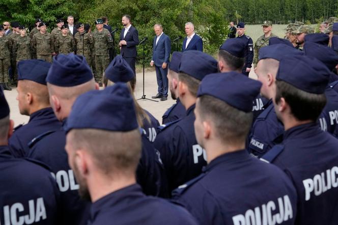 Le premier ministre polonais, Donald Tusk  le ministre de la défense, Władysław Kosiniak-Kamysz, et le ministre de l’Intérieur, Tomasz Siemoniak, s’adressent aux forces de l’ordre à Dubicze Cerkiewna, dans l’est de la Pologne, le  29 mai 2024.