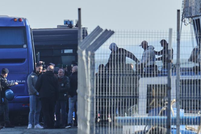 Un migrant escorté par des policiers débarque du navire de la marine italienne « Libra », tandis que les autorités italiennes transfèrent 40 migrants sans autorisation de séjour vers des centres de rétention gérés par l’Italie en Albanie, à Shëngjin, le 11 avril 2025.