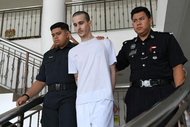 Le ressortissant français Tom Félix (au centre), escorté par des officiers de la police royale malaisienne au tribunal de grande instance d’Alor Setar, le 16 juin 2025.