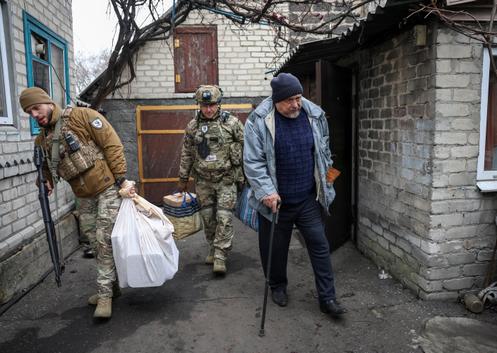 Des membres des « White Angel » portent assistance à un habitant, lors de l’évacuation de Dobropillia, dans l’oblast de Donetsk, en Ukraine, le 9 décembre 2025.