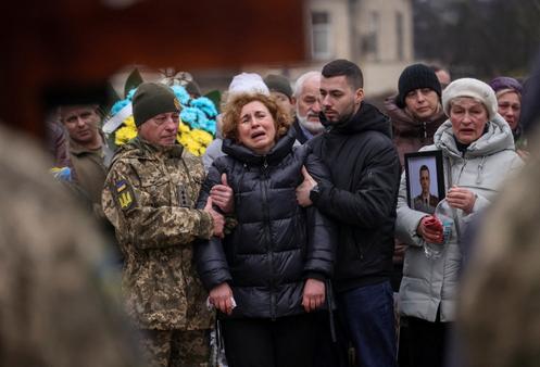 Les proches d’un soldat ukrainien récemment tombé au combat, dans un cimetière militaire nouvellement ouvert à Lviv, en Ukraine, le 11 décembre 2025.