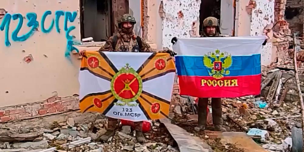 Sur cette image extraite d’une vidéo, des soldats russes brandissent le drapeau du pays et celui de leur unité à Siversk (Ukraine), le 11 décembre 2025. - SERVICE DE PRESSE DU MINISTÈRE DE LA DÉFENSE  RUSSE / AP