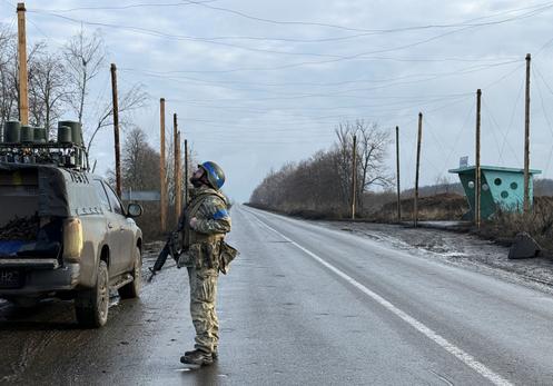 Un soldat ukrainien scrute le ciel à la recherche de drones de combat russes, près de la ville frontalière de Koupiansk, en Ukraine, le 12 décembre 2025.