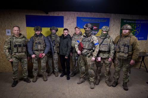 Photo du service de presse présidentiel ukrainien montrant le président Zelensky, au centre, avec le général Oleksandr Syrsky, à gauche, et des soldats de la 14e brigade mécanisée lors d’une visite sur la ligne de front à Koupiansk, le 12 décembre 2025.