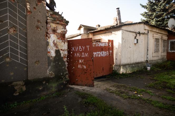 Des maisons détruites dans le centre de Marioupol, le 18 novembre 2025. Sur le portail est écrit : « Ici habité, défense d’entrer. » Pendant la guerre, de nombreux habitants s’étaient réfugiés chez eux et leurs maisons ont servi de bases arrière lors de la retraite de l’armée ukrainienne. Elles ont ensuite été pillées par les forces russes à la recherche de soldats ennemis.