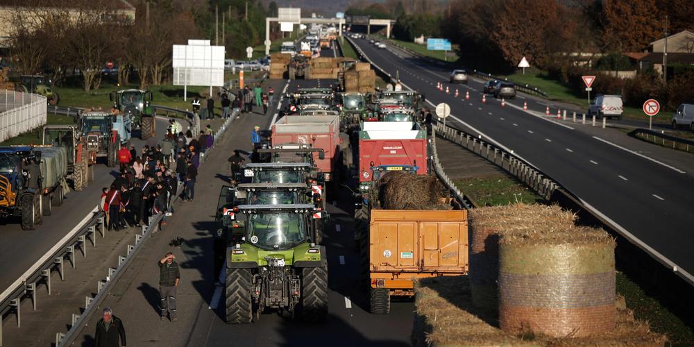 Des agriculteurs bloquent une partie de l’autoroute A64 lors d’une manifestation, à Carbonne (Haute-Garonne), le 12 décembre 2025. - VALENTINE CHAPUIS / AFP