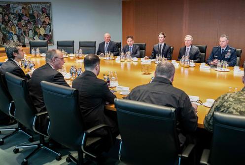 Le chancelier allemand, Friedrich Merz, avec Volodymyr Zelensky et le reste de la délégation ukrainienne, face à la délégation américaine, parmi laquelle se trouvent le gendre du président américain Donald Trump, Jared Kushner, et l’envoyé spécial américain Steve Witkoff, dans une salle de conférence de la chancellerie, à Berlin, le 14 décembre 2025.